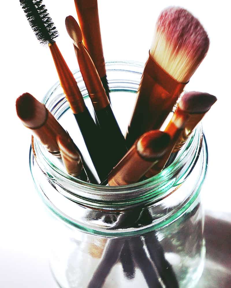 makeup brushes in a glass jar