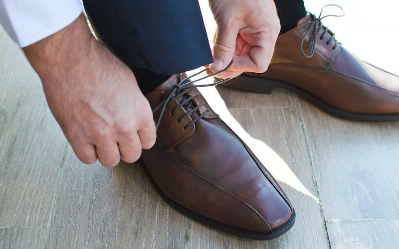a man tying leather shoes