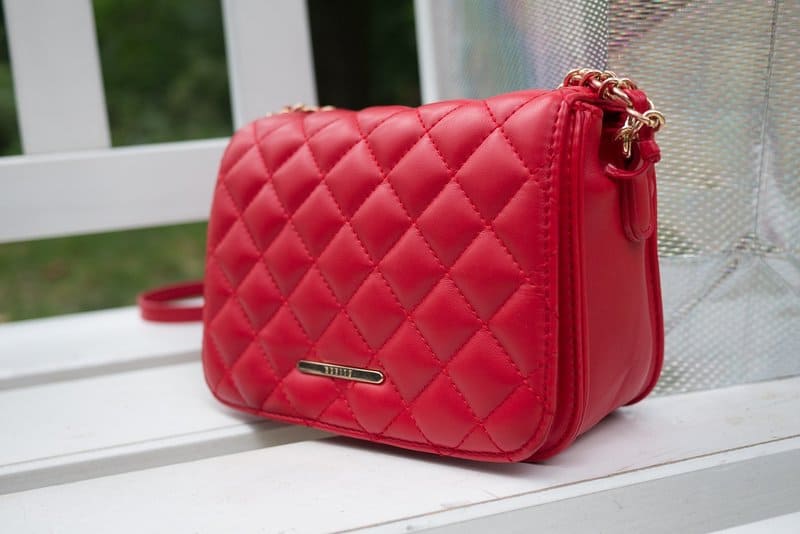 a red quilted handbag on a white chair