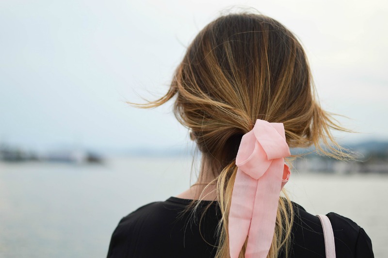 a woman wearing a scarf scrunchie in her hair