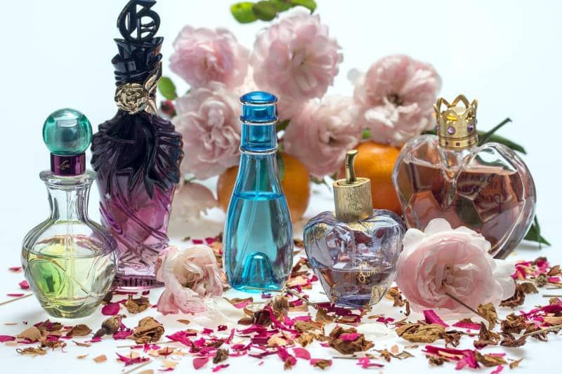 a collection of perfume bottles and flowers