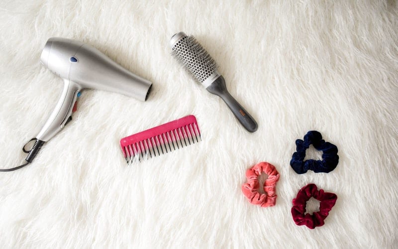 blow dryer and styling tools on a white rug