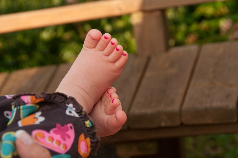 a toddler with nail polish on her toes