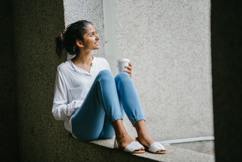 woman sitting in the sun with coffee