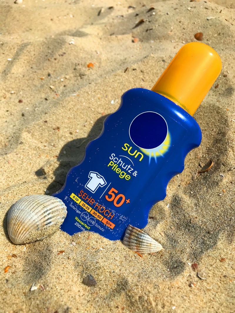 bottle of sunscreen in the sand