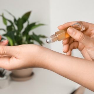 woman applying perfume to her wrist