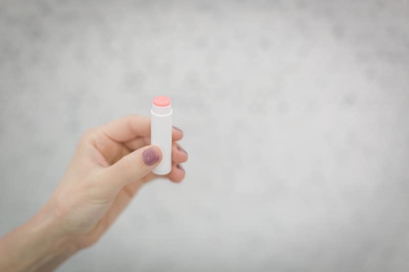 woman holding a tube of lip balm