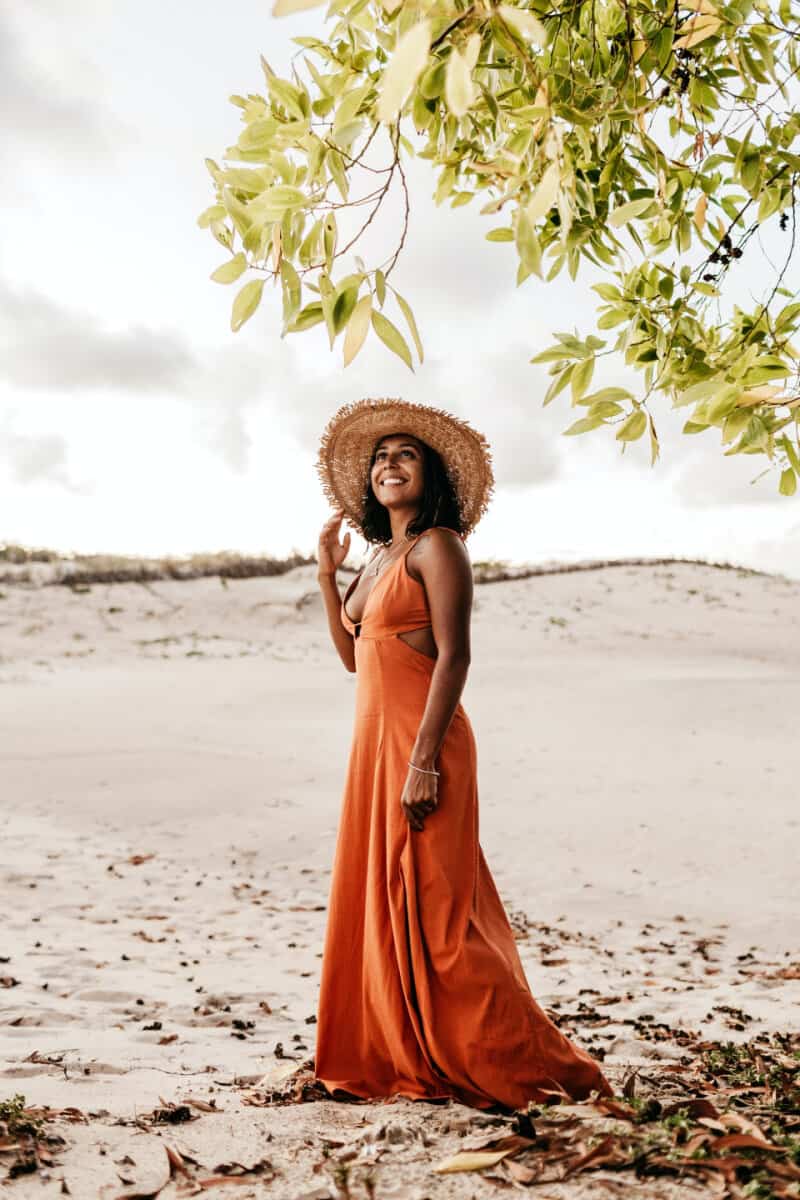 woman wearing a long orange dress on the beach