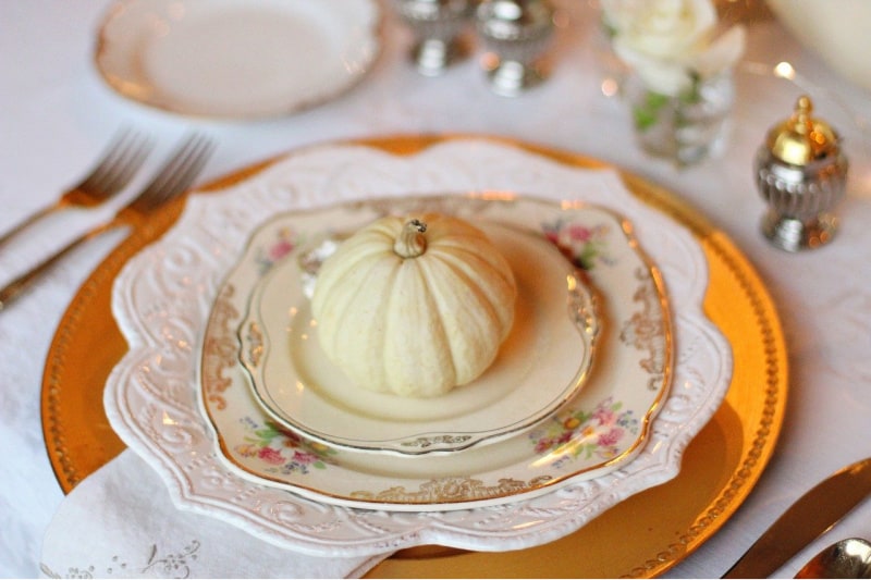 mini pumpkins on gold and cream colored plates