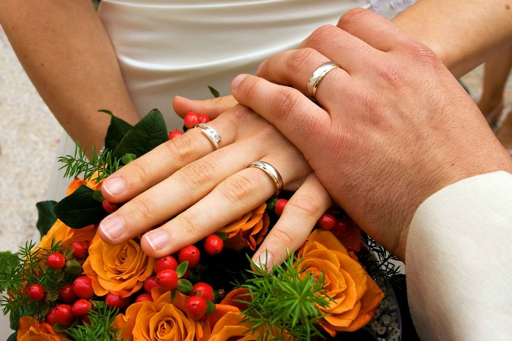 a man and woman holding hands over a bouquet