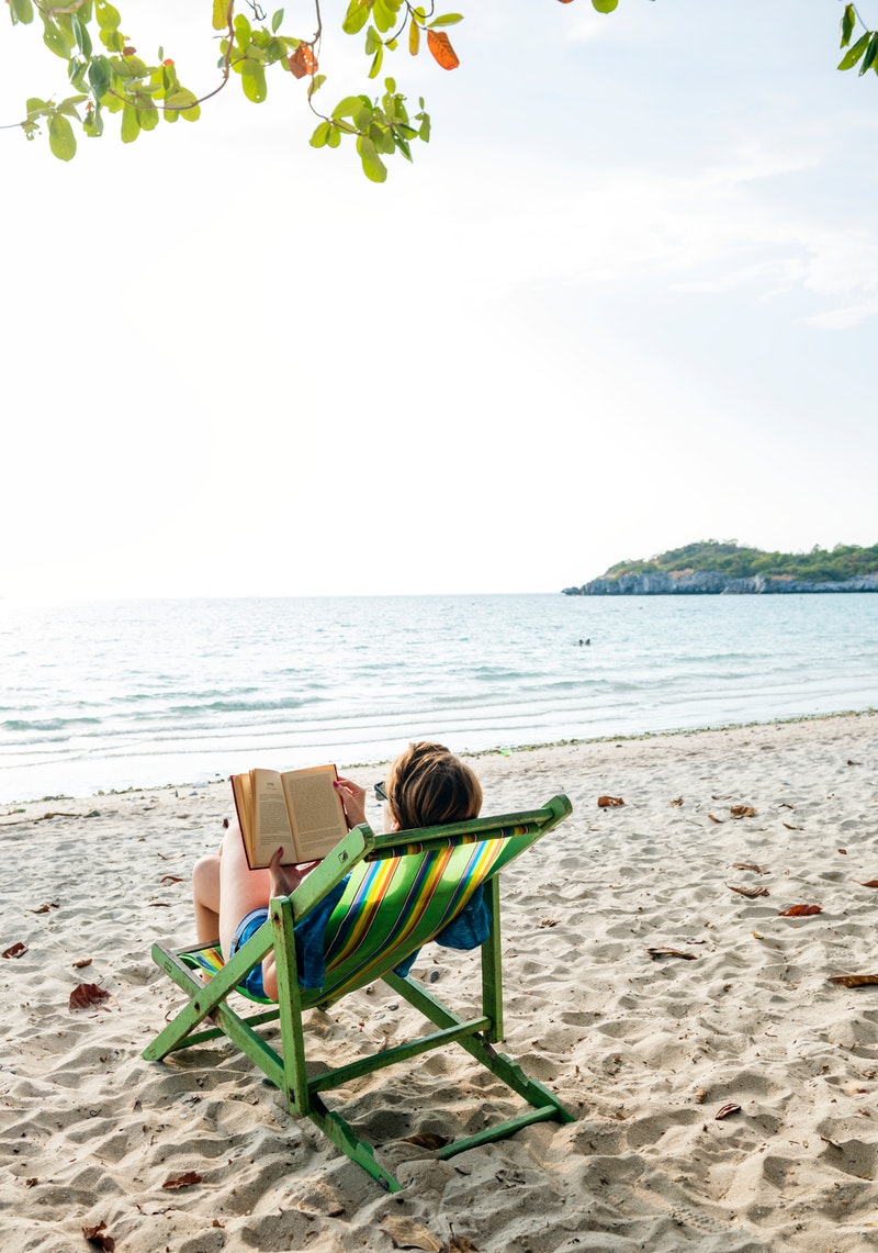 woman relaxing on the beach with a book