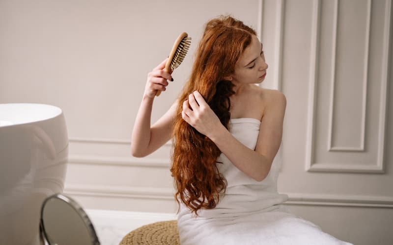 a woman in a towel brushing her hair