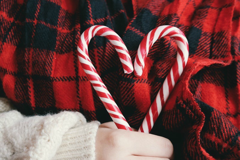 woman holding two candy canes