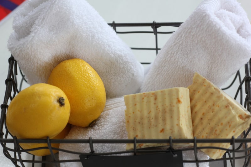lemons, soap and white towels in a basket