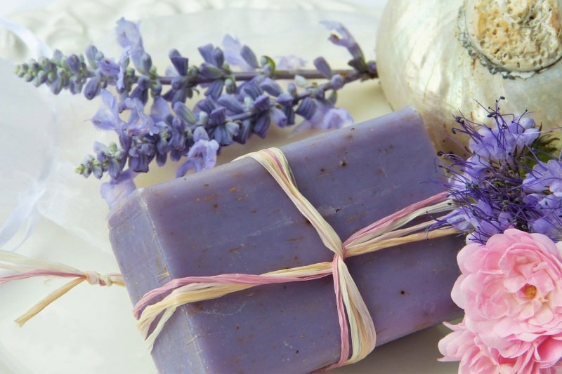 a bar of purple soap wrapped in twine near flowers