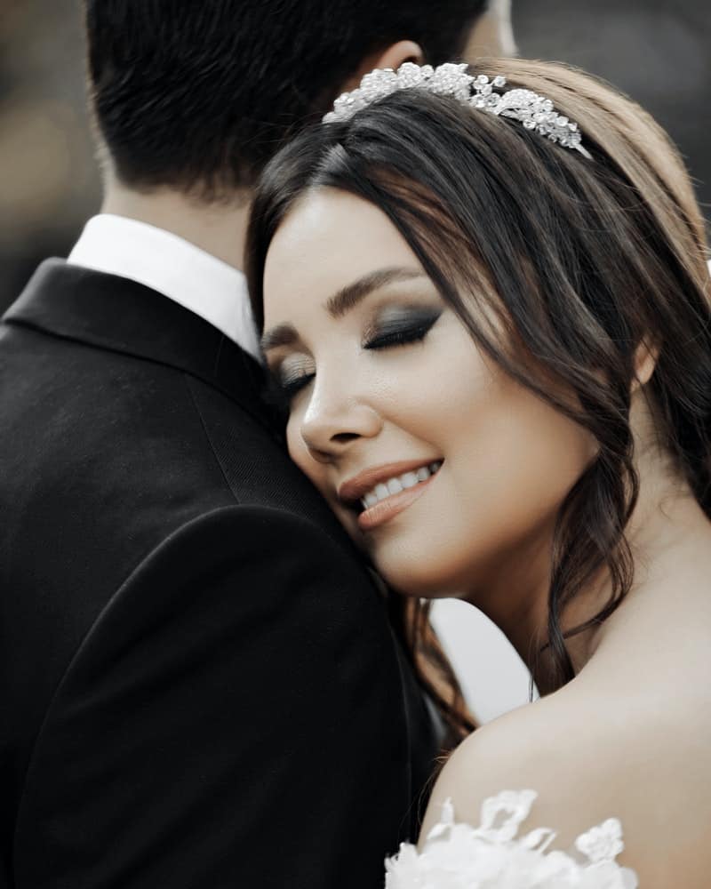 a bride hugging a groom with makeup done perfectly