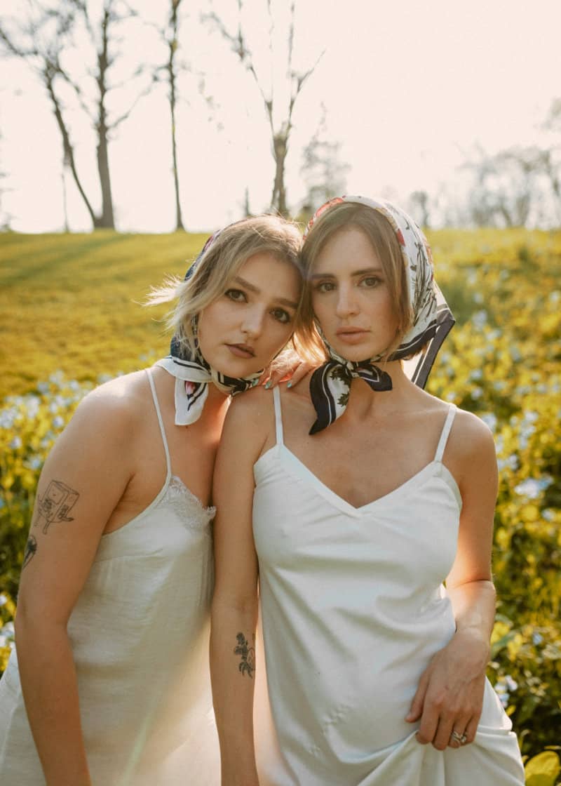 two women wearing white slip dresses