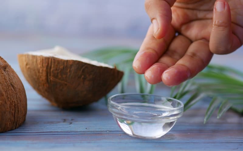 a man dipping his fingers into coconut oil