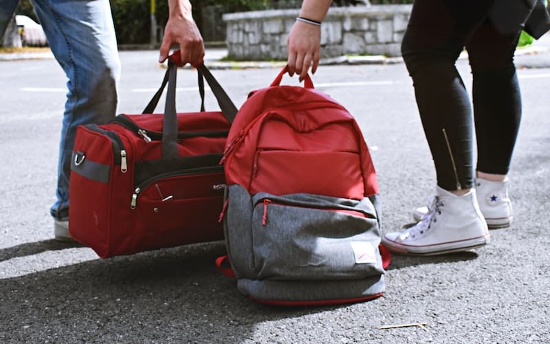 two people with red and grey backpacks