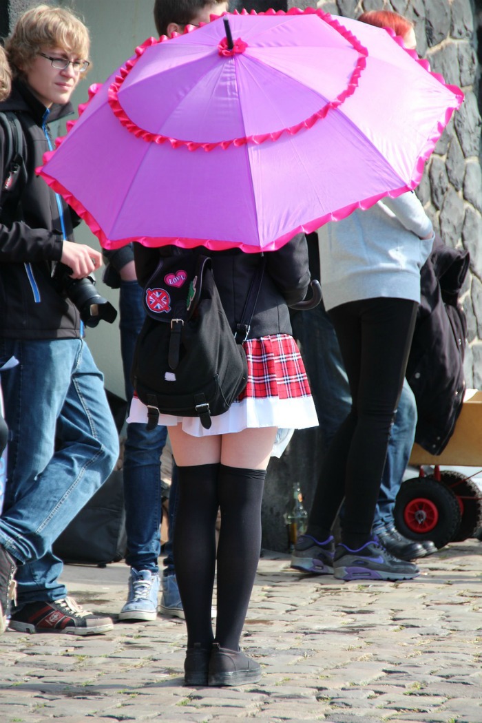 woman holding a decorated umbrella at a cosplay event