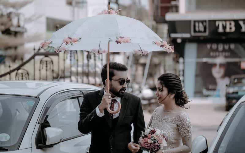 bridge and groom holding a decorated umbrella