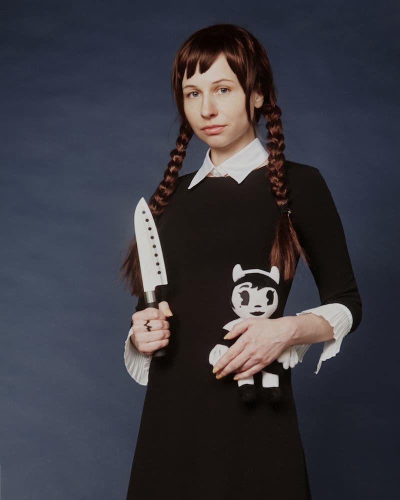 woman dressed in a black and white Halloween costume with a knife