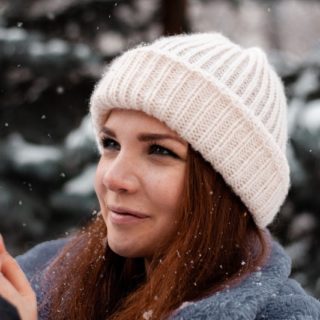 woman wearing white hat outside in the snow