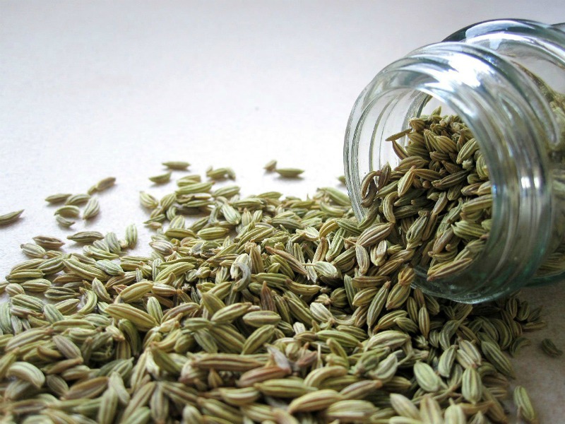 fennel seeds spilling out of a glass jar