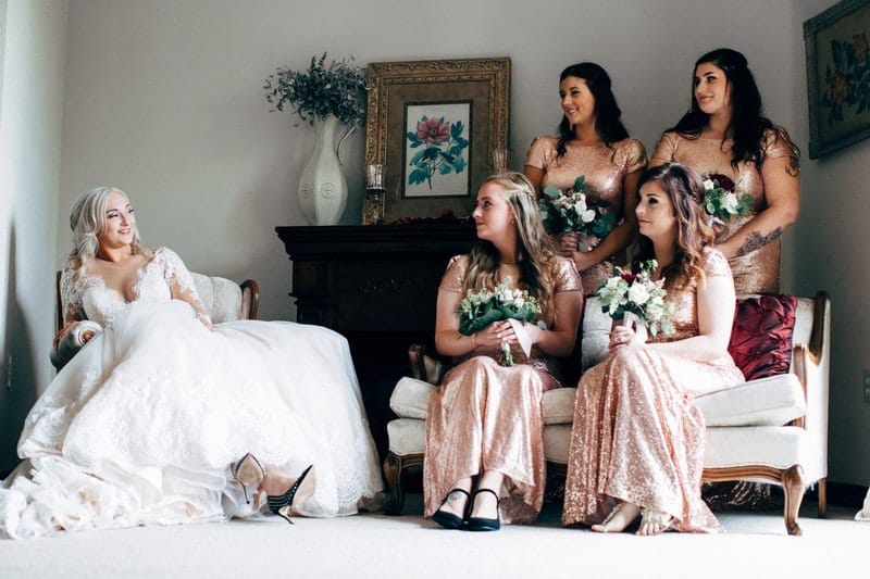 a bride and bridesmaids sitting on a couch