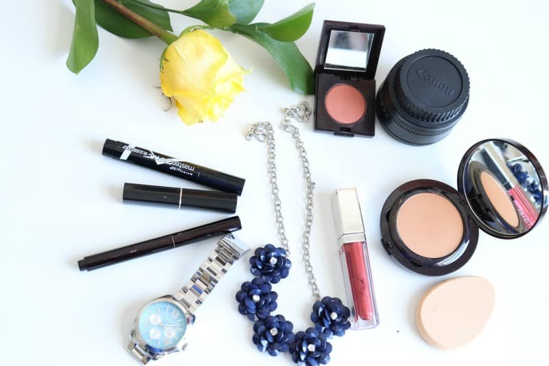 beauty products and jewelry on a white table