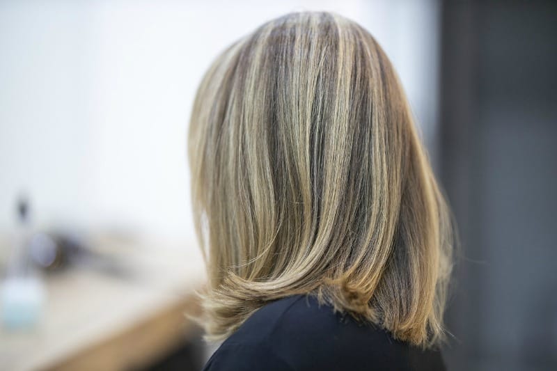 woman sitting at a hair salon with short fine hair