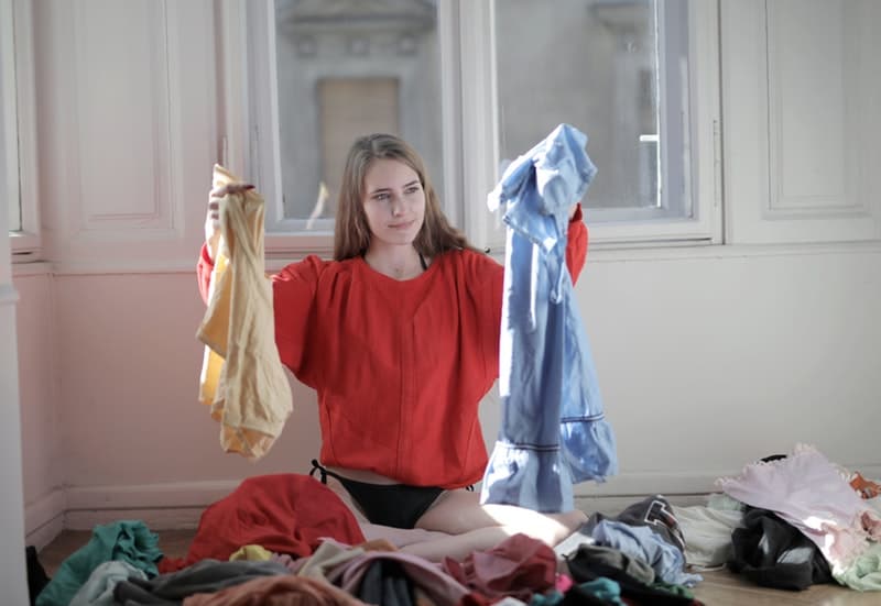 a woman holding clothes that need to be cleaned