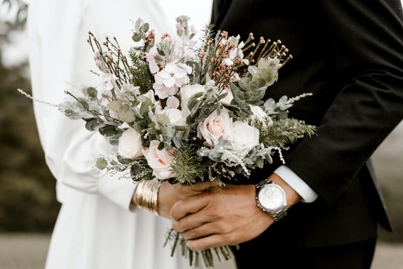 bride and groom holding flowers for a fall wedding