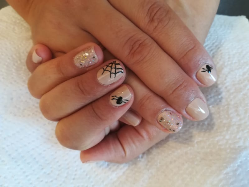 a woman with a spiderweb nail design on her nails