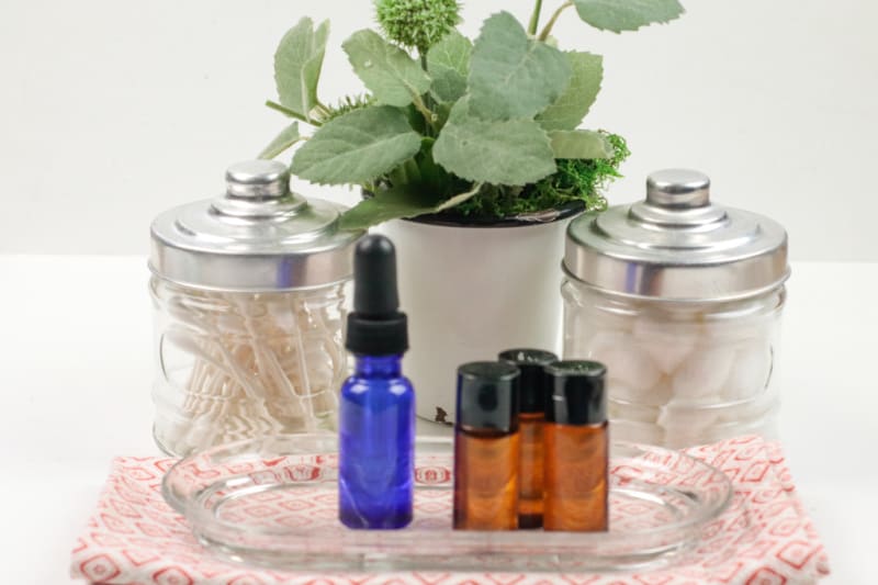 jars with cotton swabs, a plant, and essential oils for face care