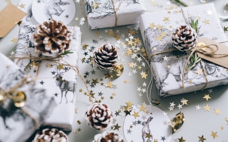 Christmas presents wrapped in pretty paper with pine cones and star glitter