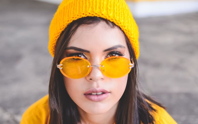 a woman with a yellow knit cap with glasses