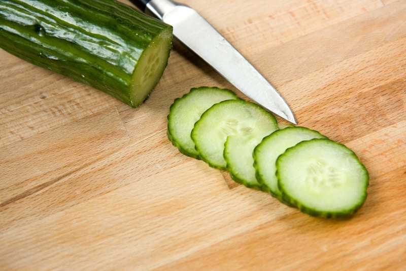 sliced cucumbers on a wooden cutting board