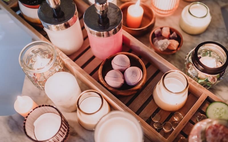 a wooden rack with candles and pampering bath products