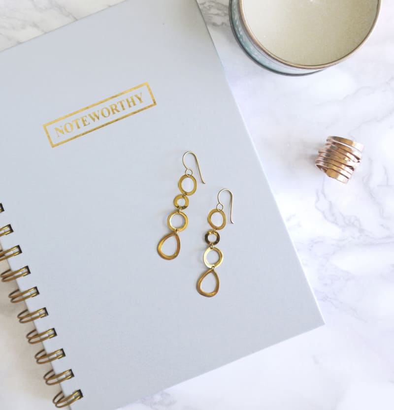 a white planner with gold jewelry