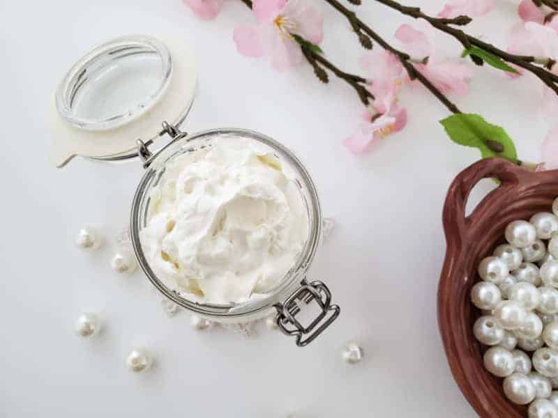 a jar of white night cream with pearls and flowers