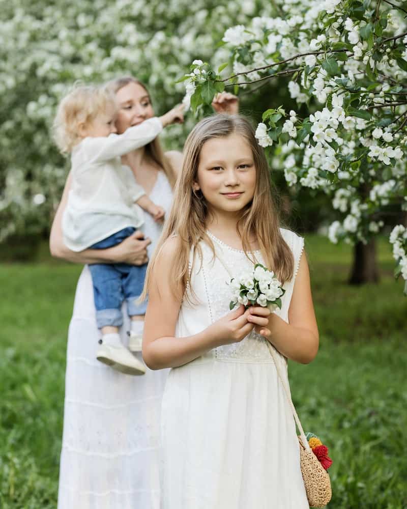 wedding guests in a field picking flowers from a tree