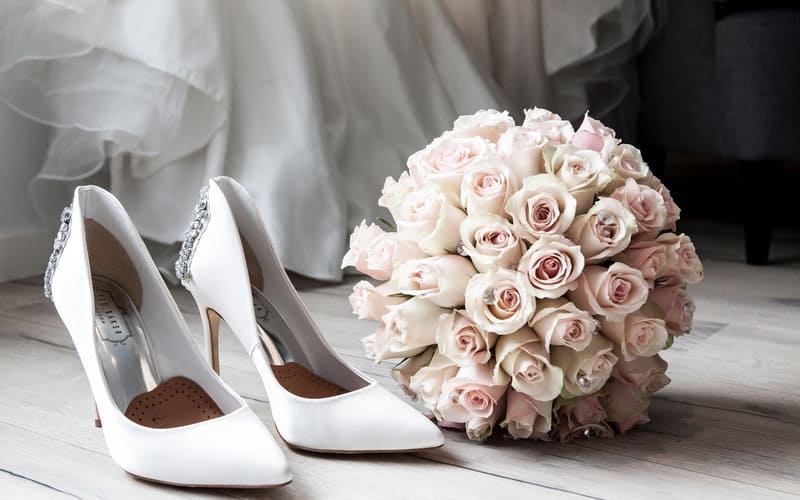 white leather shoes next to flowers