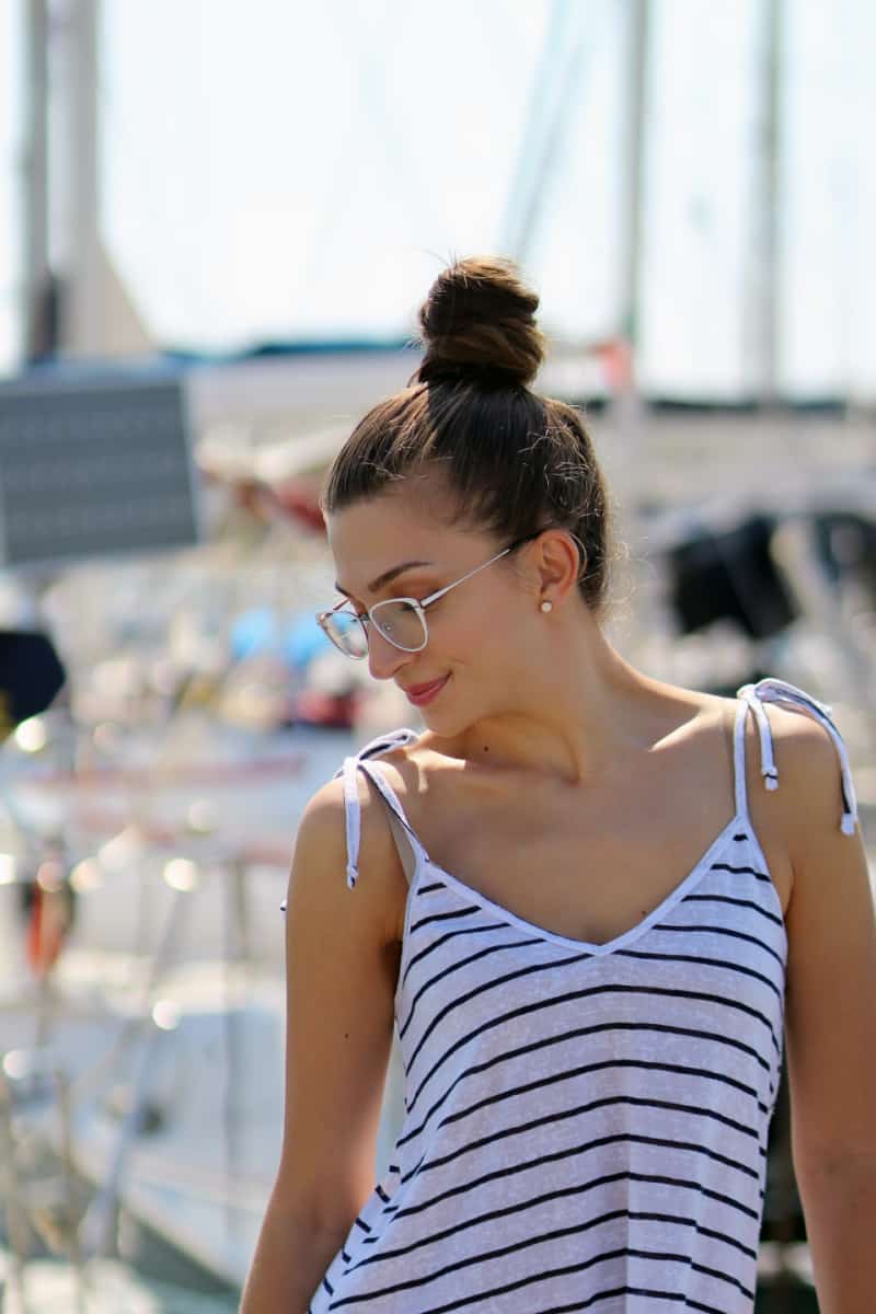 a woman wearing a striped summer top and sunglasses