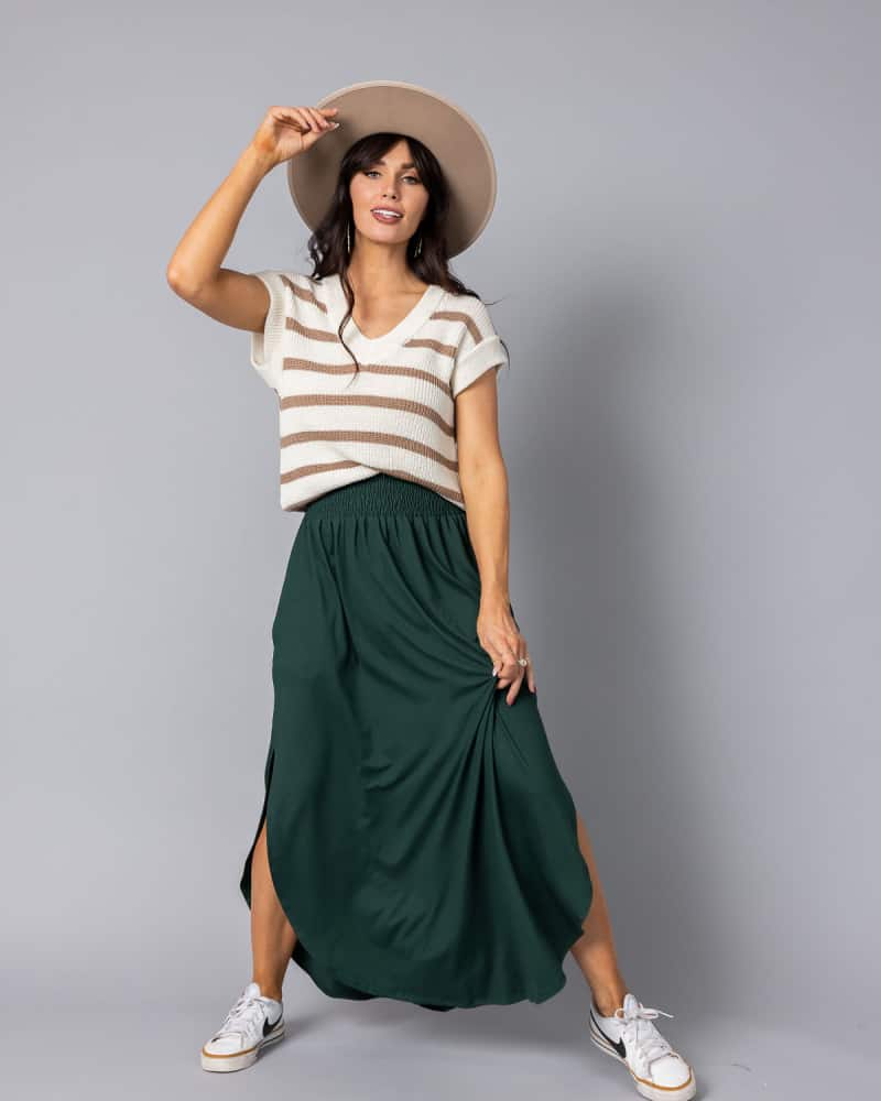a woman wearing a green maxi skirt and t-shirt with sneakers