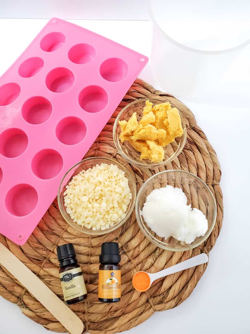 ingredients to make lotion bars on a wicker mat