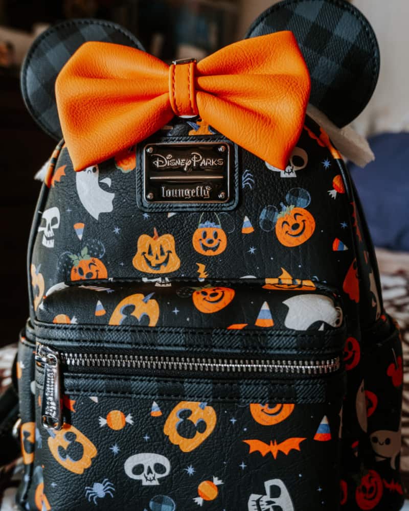 a black and orange Disney backpack with a bow