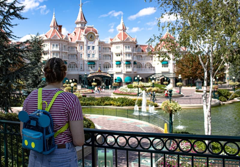 a woman wearing a blue Mickey Mouse backpack