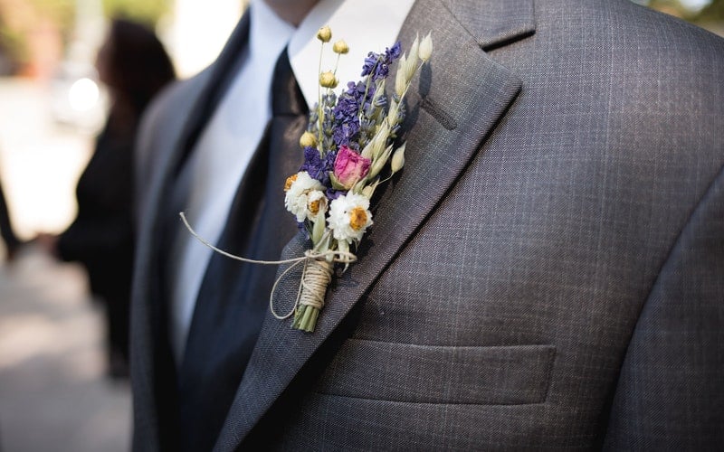 a boutonniere in a grey suit jacket