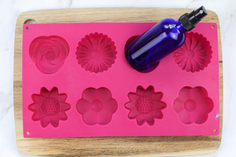 a pink flower soap mold and spray bottle